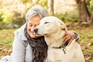 Seniorin kuschelt mit ihrem Hund