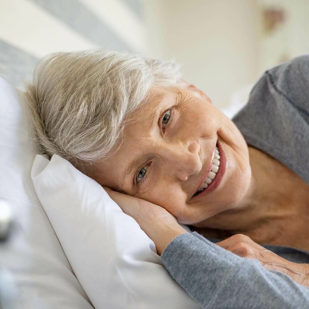 seniorin liegt im bett opt