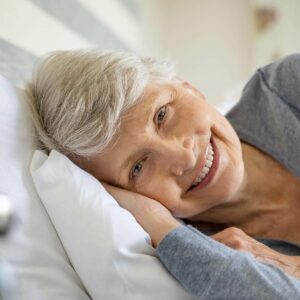 seniorin liegt im bett opt