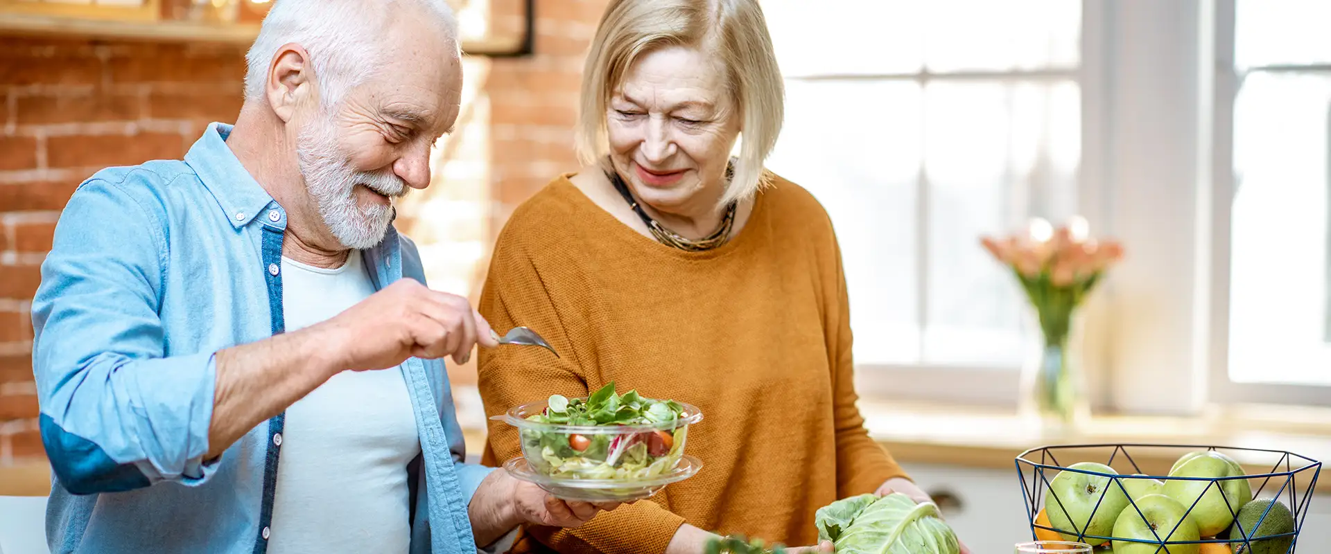 senioren bereiten sich einen salat zu