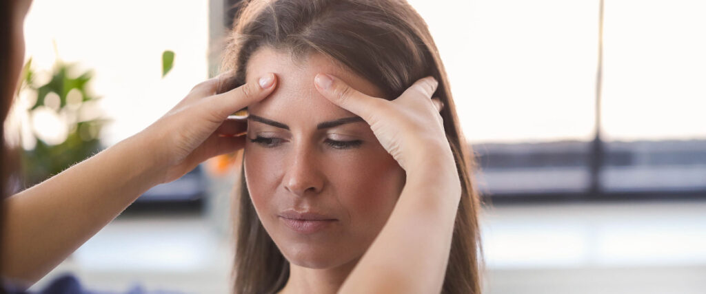 Stressbewältigung in der Pflege: Pflegende Angehörige bekommt Massage des Kopfes gegen den Stress