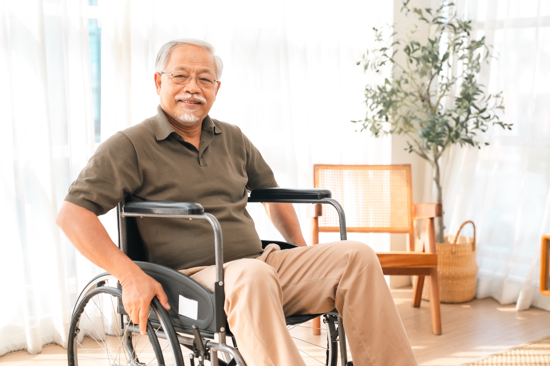 father's day concept, elderly man in wheelchair at home with calm smile