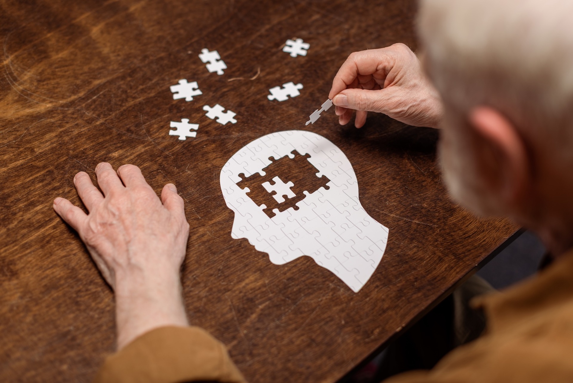 senior completing brain puzzle on wooden table 2026 03 13 01 07 18 utc 2
