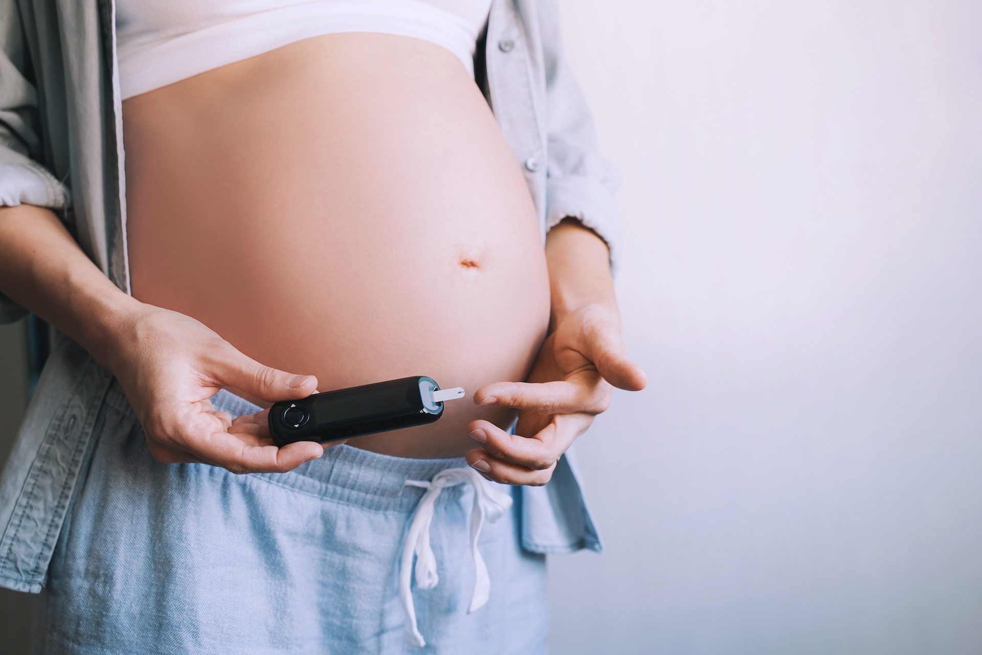 gestational diabetes test during pregnancy. pregnant woman checking blood sugar level with glucometer.