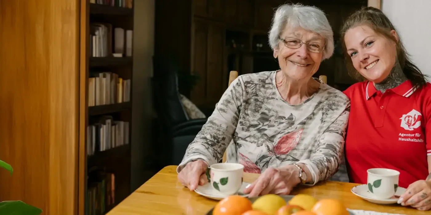 Seniorin und Haushaltshilfe trinken gemeinsam Kaffee