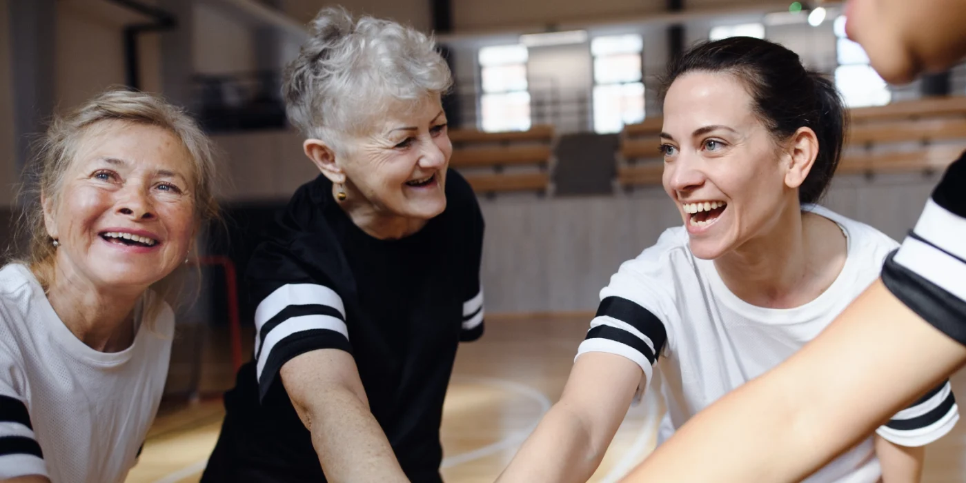 Eine Gruppe von Frauen aus verschiedenen Altersklassen beim Sport in einer Turnhalle