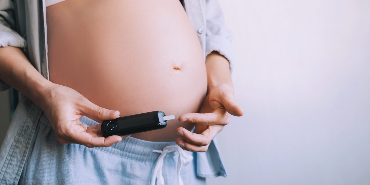 gestational diabetes test during pregnancy. pregnant woman checking blood sugar level with glucometer.