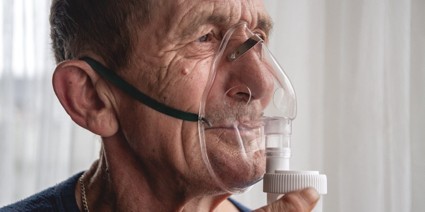 elderly senior with an oxygen mask in quarantine