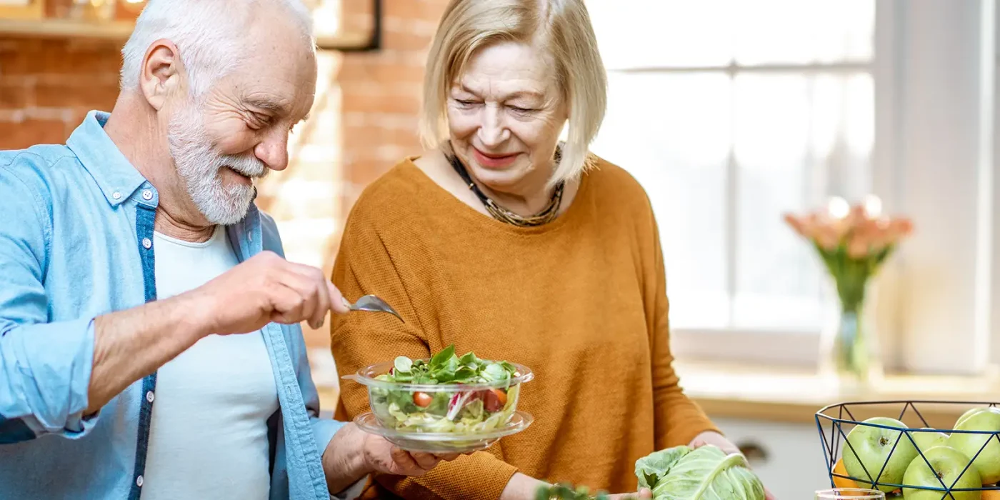 senioren bereiten sich einen salat zu