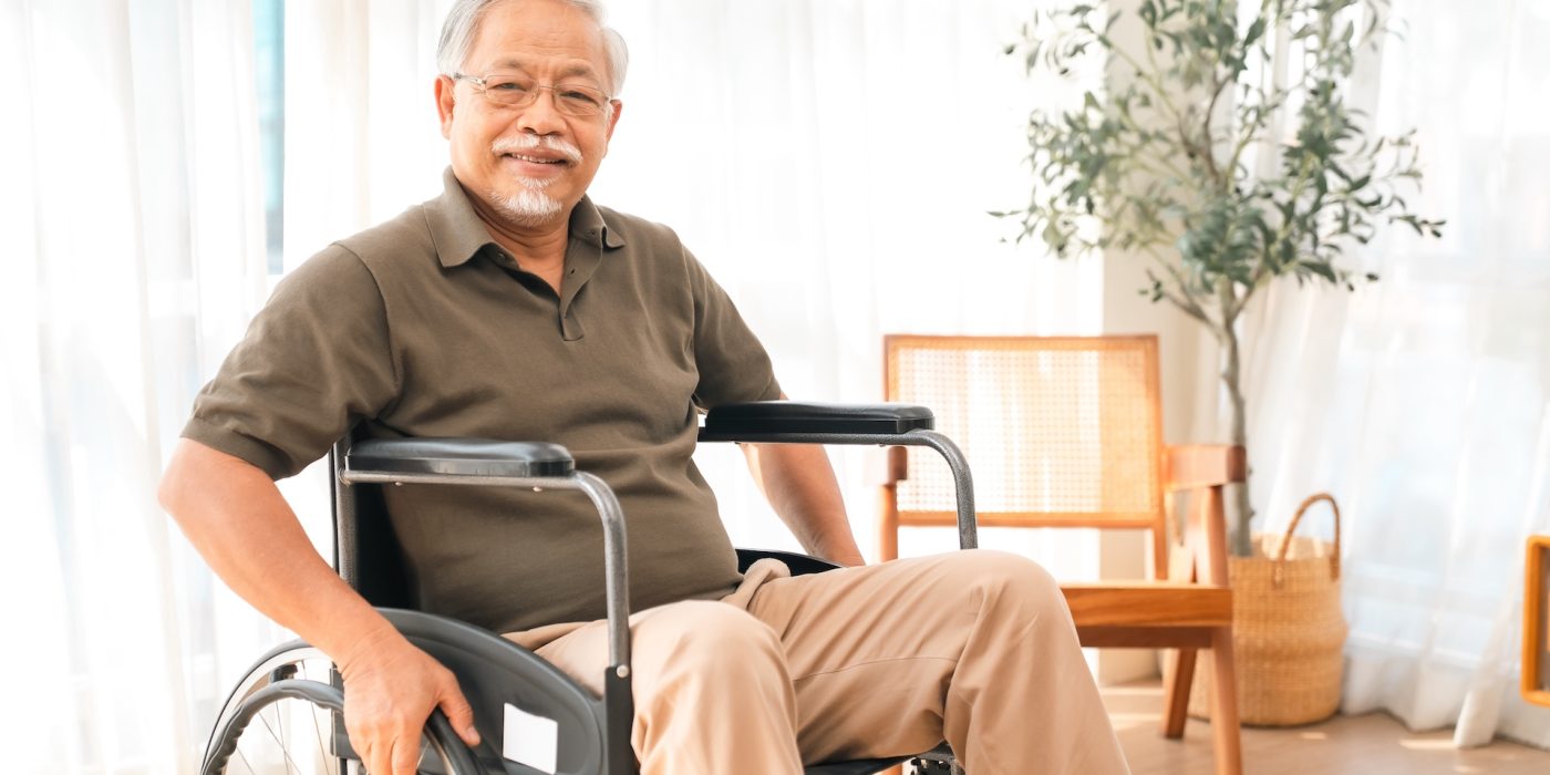 Father's Day concept: an elderly man in a wheelchair at home with a calm smile